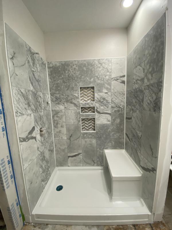 Marble-look tile shower with a bench